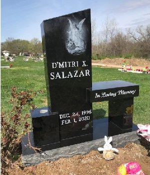 Black granite bench monument with an etched angel and the words In Loving Memory