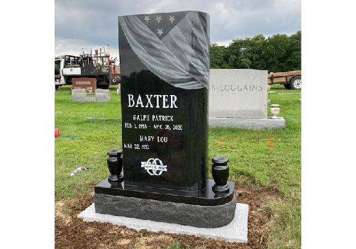 Black granite upright monument with a laser etched flag drape across the top