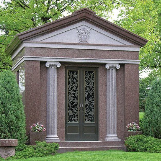 Private granite mausoleum in red granite with carved columns and bronze doors