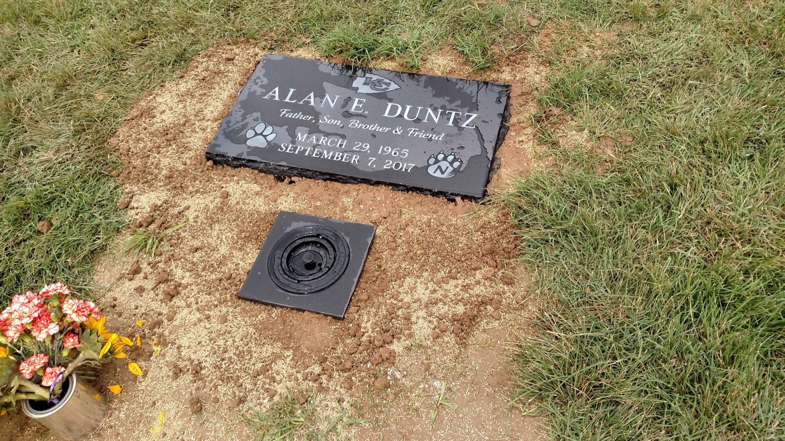 Black granite flat grass marker etched with paw prints, newly set in fresh ground